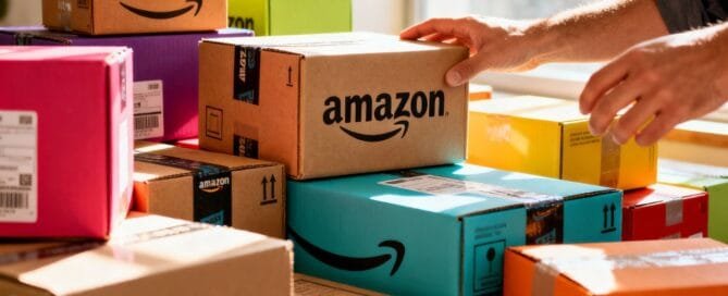 Hands arranging colorful Amazon product boxes for sales.